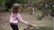 Child girl picks a ripe red apples from a tree branch