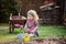 Child girl planting hyacinth flowers in spring garden