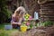 Child girl planting pink hyacinth flowers in spring garden