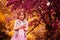 Child girl playing with flowers near blooming crab apple tree in spring