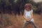 Child girl playing with leaves in summer forest. Nature exploration with kids