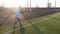 A child girl playing with soccer ball under sun light. Green field in city park at sunny day. Action sport outdoors of