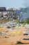 A child girl plays in piles of trash while her mother burns it on the beach of Kollam, Kerala