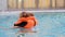 Child girl in the pool in a life jacket learns to swim. Swimming baby in the water