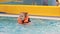 Child girl in the pool in a life jacket learns to swim. Swimming baby in the water