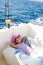 Child girl sailing relaxed on boat deck ejoying a nap