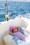 Child girl sailing relaxed on boat deck ejoying a nap