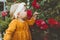 Child girl smelling flowers red roses in garden childhood baby summer lifestyle