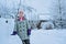 Child girl with snow castle on snowy winter backyard