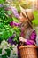 Child girl in straw hat in lilac Garden. Girl smells the flowers, inhale the aroma in springtime. Gardening.