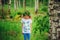 Child girl in summer forest. Idea for nature crafts with kids - leaf print shirt and natural wreath.