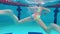 Child girl or teenager swims underwater in the pool. Shooting a video underwater as a child swims in a pool. A teenage