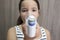 Child girl using medical spray for breath. Inhaler, spacer and mask