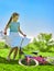 Child girl wearing red polka dots dress rides bicycle into park.