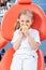 Child girl in white clothes at reception at a pediatric dentist smiles and laughs. little girl bites a big green apple with her