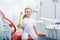 Child girl in white clothes at reception at a pediatric dentist smiles and laughs. little girl holds a big toothbrush in the