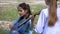 Child girls singer strum with acoustic guitar while her girlfriend standing listening music performer