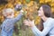 Child gives to happy mother flowers. Fall colors background