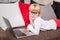 Child with glasses lying on couch with laptop in front of her