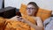 Child in Glasses Watching Interesting Video on a Smartphone Lying in a Cozy Bed