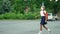 Child goes back to school. Cute pupil with backpack. Girl in safety masks jumping over a puddle