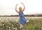 Child on green daisy grass in a summer park sunset time doing balerina