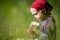 Child in green wild meadow eating wild strawberries. Summer happy times.