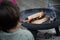 Child grilling a hotdog in an open fire