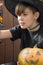 Child in Halloween costume with pumpkins, and lamp