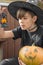Child in Halloween costume with pumpkins, and lamp
