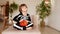 a child in a halloween costume sits with pumpkin