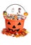 Child halloween pumpkin bucket with candy and fall