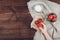 Child hand holding strawberry, sugar and cup of strawberries on linen cloth and rustic wooden background. Summer healthy eating