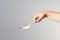 Child hand holding white spoon in right hand trying to hold it in right way on the white background