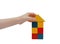 Child hand make a building with colored blocks