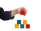 Child hand make a building of colored blocks