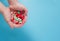 Child hand with medical colorful pills on blue background.