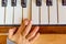 Child hand on the shiny piano keys. Top view