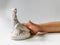 Child hand takes dinosaur model molded from plaster