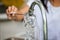 Child hand washing spoon over the sink