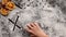 Child hand writing the word xmas in the flour