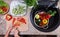 Child hands chopping vegetables for a salad - top view