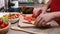 Child hands cutting cherry tomato for salad - side view