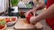 Child hands cutting a red bellpepper for a vegetables salad