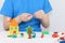 Child hands molding bright house, sheep, flowers