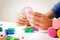 Child hands playing with modeling clay or plasticine on white table