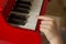 Child hands playing toy piano
