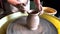 Child hands sculpt earthenware jug on pottery wheel