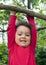 Child hanging on a tree branch