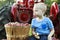 Child having fun apple picking and sitting on a red antique tractor